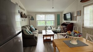 Una cocina amplia con refrigerador, mesa de comedor de madera y ventilador de techo.