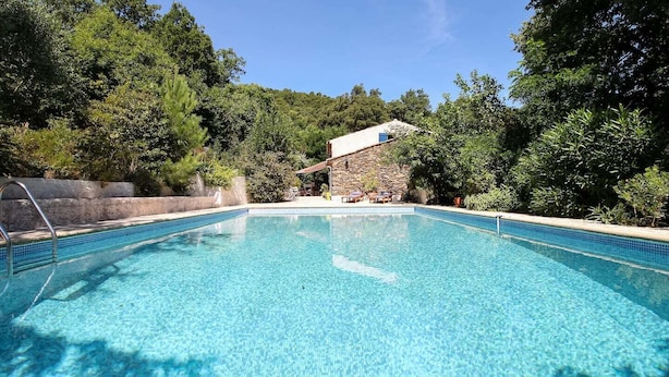 A clear blue pool with a stone building in the background surrounded by trees. - Bastide nestled in the heart of nature (La Garde-Freinet)