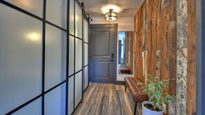 A hallway with a wooden bench, a potted plant, and a door. - Modern Rustic Loft Suite in Downtown Blue Ridge (Blue Ridge)