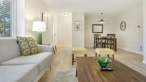 Un salon comprenant un canapé, une table basse et un coin repas avec des chaises et une table.
