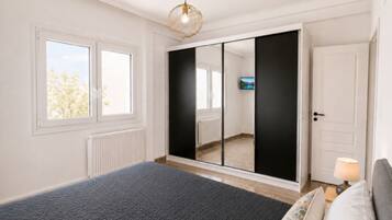 Ein Schlafzimmer mit einem Bett, einem Kleiderschrank, einem Fernseher und einem Fenster.