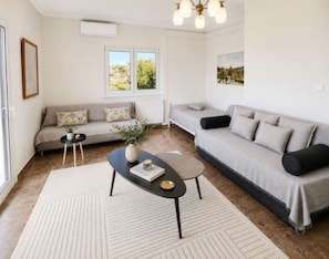 A modern living room with a sofa, a coffee table, and a large window.