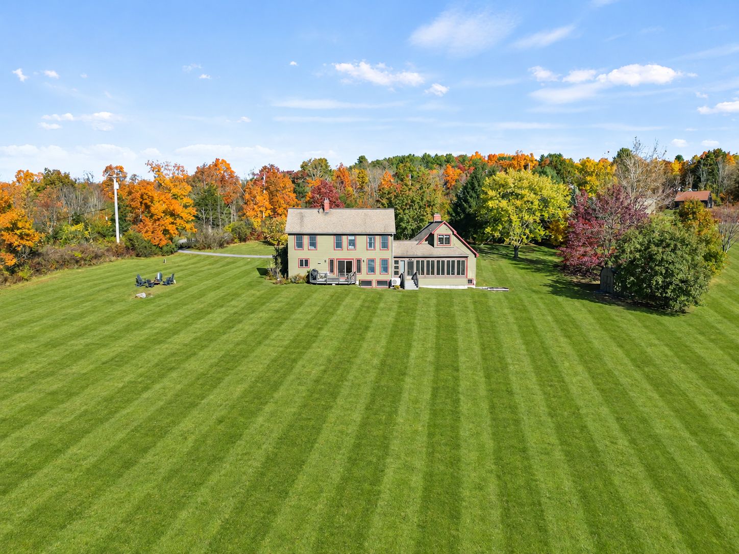 A large two-story house with a well-maintained lawn and a driveway leading to the entrance.