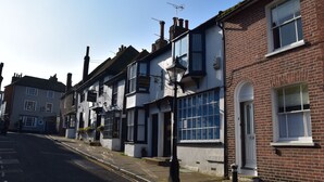 A row of traditional buildings with a dental surgery sign, a pub sign, and a number 5 sign on a brick building. - 5 East Street  (Rye)