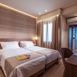 A hotel room with a double bed, a desk, and a chair. - Metropole Urban Hotel (Heraklion)