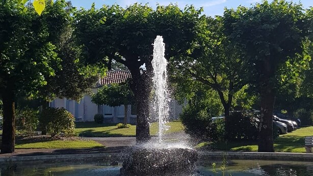 Une fontaine dans un parc, sous un ciel dégagé.