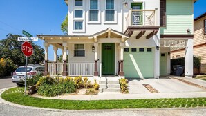 A two-story house with a green front door, a covered porch, and a garage.