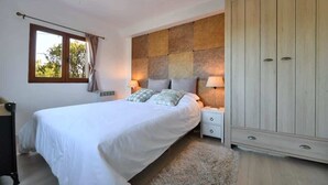 A bedroom with a bed, nightstands, a wardrobe, and a window with curtains. - Hill-top haven with private pool & endless views (Belvezet)