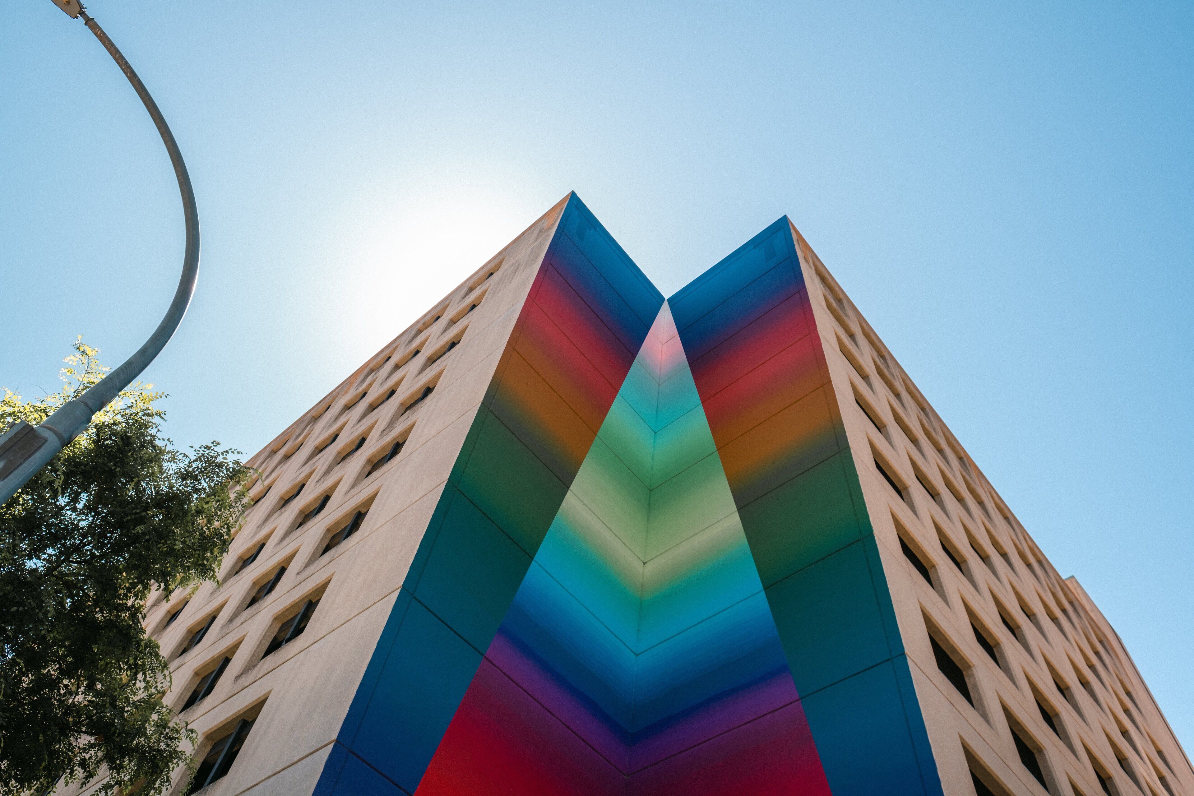 A tall building with a unique facade featuring a rainbow gradient.