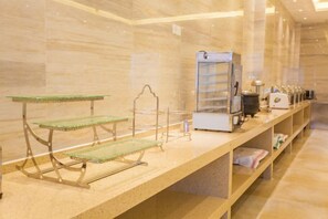 A hotel reception area with a counter, a coffee machine, and a glass display case. - Lavande Hotel (Guilin Railway Station Mixc) (Guilin)