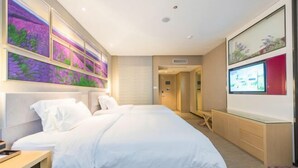 Una habitación de hotel moderna con una cama grande, un escritorio y un televisor.