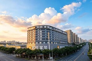 A multi-story hotel with a curved facade, multiple balconies, and a clear sky with clouds. - Lavande Hotel (Guilin Railway Station Mixc) (Guilin)