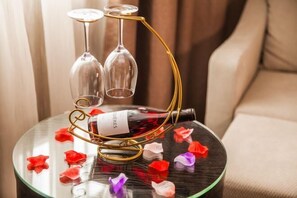 A glass table with a wine bottle and two glasses on a stand. - Lavande Hotel (Guilin Railway Station Mixc) (Guilin)