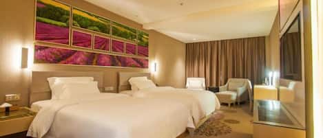 Una habitación de hotel con dos camas, una gran obra de arte en la pared, un rincón de descanso con una silla y una mesa de vidrio.