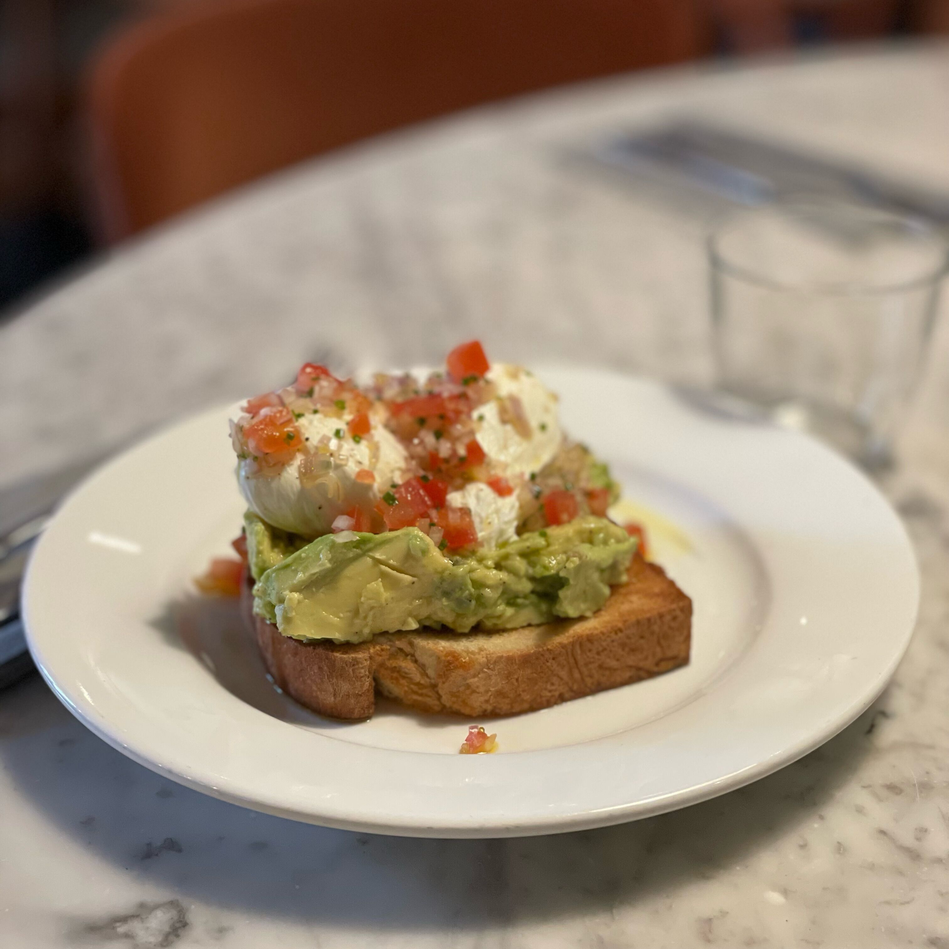 A plate with a sandwich on a marble table.