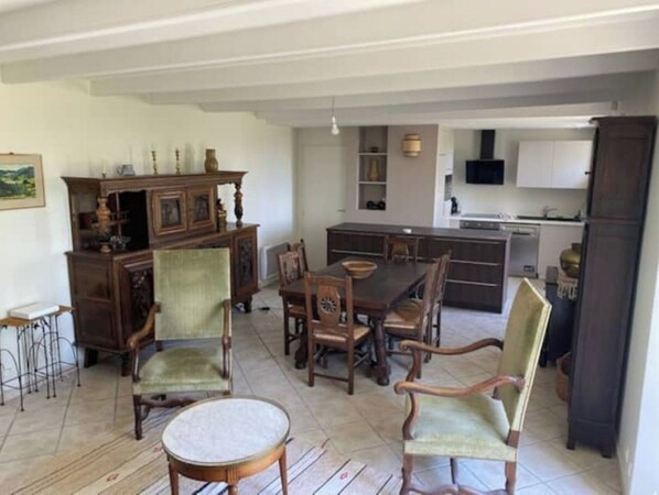 A spacious dining area with a wooden table and chairs, a kitchen with white cabinets, and a large island.