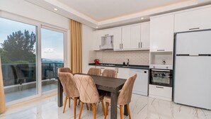 Une cuisine moderne avec des meubles blancs, une table en bois foncé et six chaises.