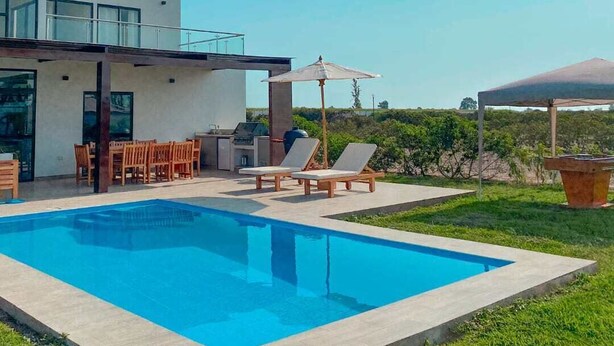 A modern house with a swimming pool, outdoor furniture, and a barbecue area. - Pisco Villa: Private Pool & Games on 1400m² (Pisco)