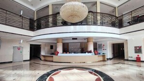 A spacious lobby with a central reception desk, a large chandelier, and a circular marble design on the floor. - Mengshiyuan Hot Spring Resort (Anning)