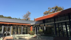 A modern building with large windows and a covered entrance area. - Mengshiyuan Hot Spring Resort (Anning)