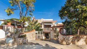 Ein zweistöckiges Haus mit Steinverkleidung, einem verschlossenen Eingang und einem überdachten Veranda.