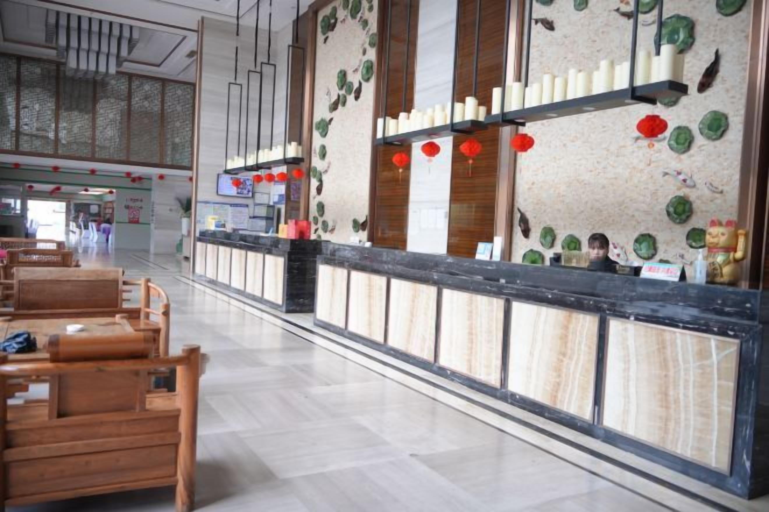 Zona de recepción con mostrador, asientos de madera y detalles decorativos.
