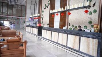 Zona de recepción con mostrador, asientos de madera y detalles decorativos.
