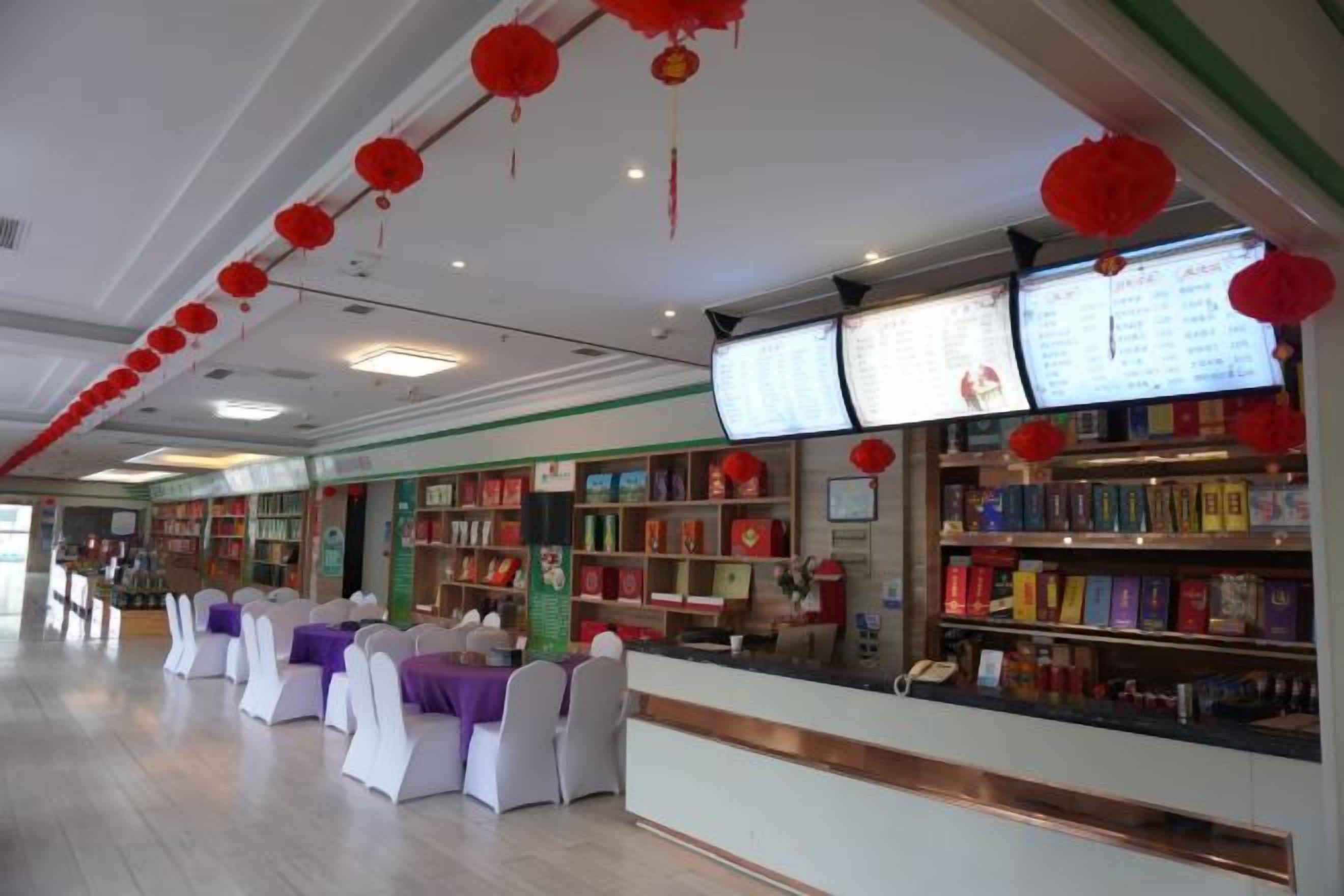 Una librería con estanterías, mesas con sillas blancas y faroles rojos colgando del techo.