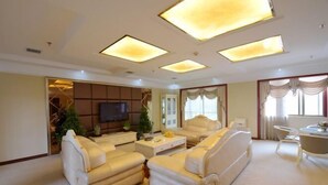 A spacious living room with a large sofa set, a flat-screen TV, and a dining area with a table and chairs. - Censhan Hotel (Hengfeng)