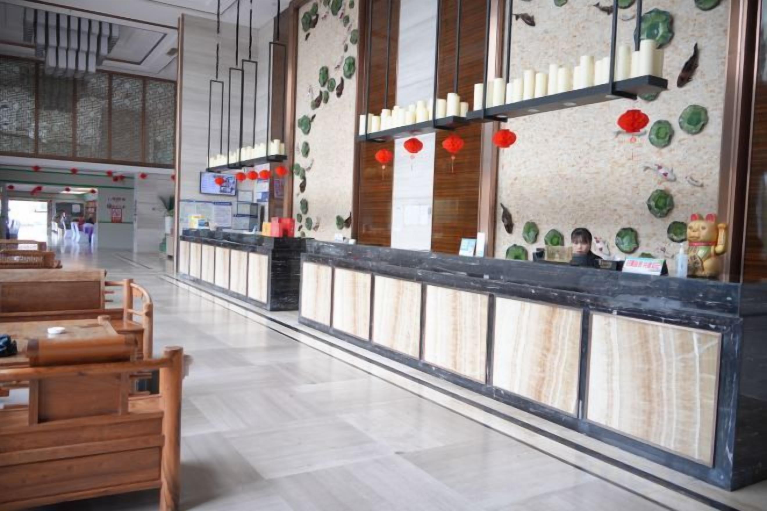 Un área de recepción con mostrador, asientos y detalles decorativos.