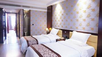 Habitación de hotel con dos camas, un espejo grande y un papel tapiz estampado.