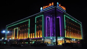 A hotel with a modern facade, illuminated by colorful neon lights. - Censhan Hotel (Hengfeng)