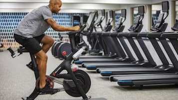 A gym with multiple treadmills and a person using an exercise bike.