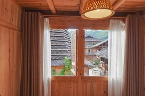 Un interior de madera con una ventana que muestra arquitectura tradicional en el exterior.
