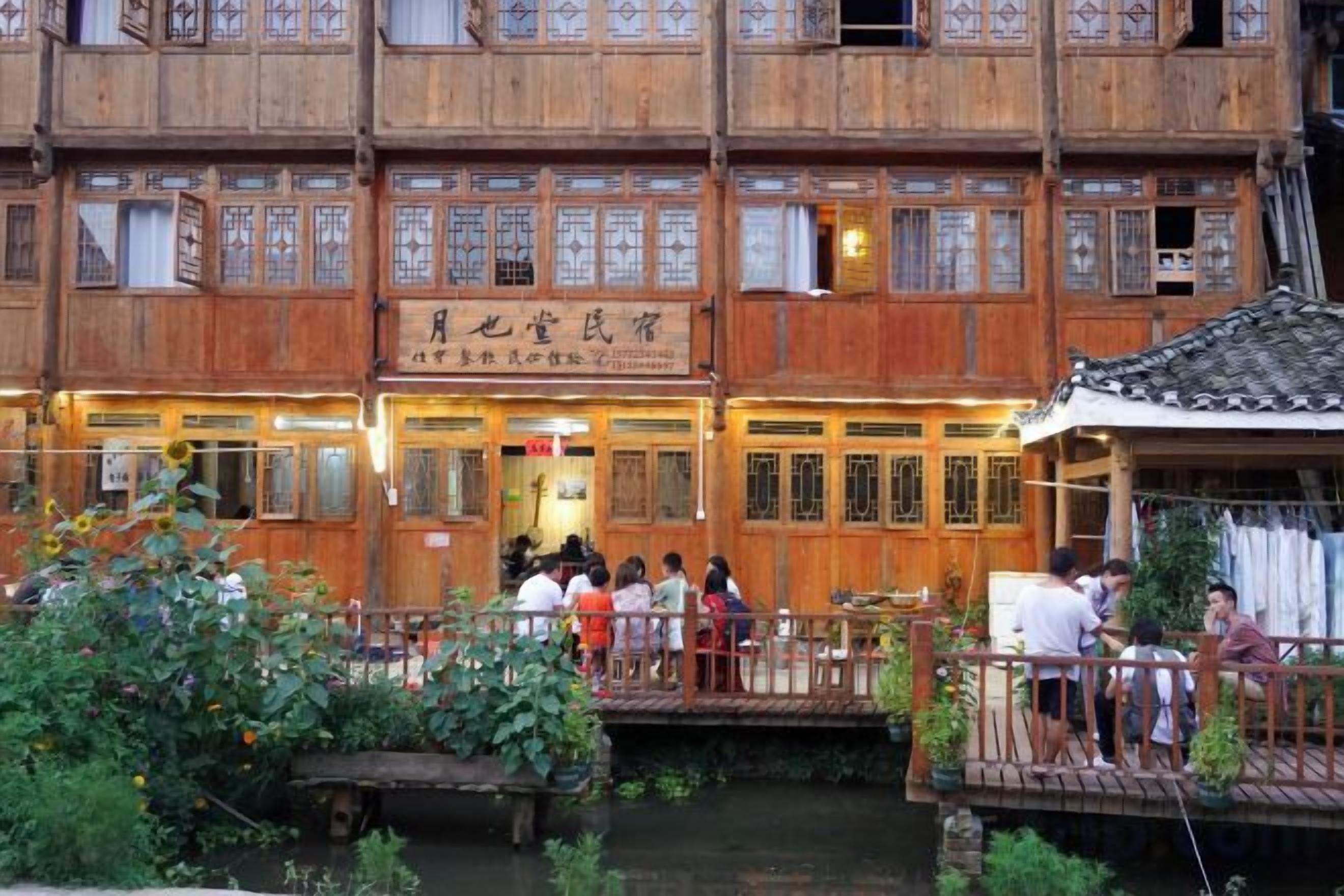 A traditional wooden building with multiple windows and a sign indicating a restaurant.