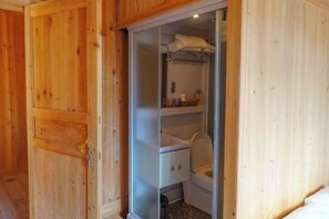 A wooden-paneled bathroom with a toilet, sink, and storage cabinets. - Yueyetang Inn(Liping Huanggang Dong nationality Branch) (Liping)