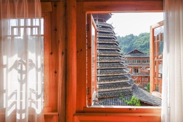 A traditional Japanese building with a curved roof and a view of a forested hillside. - Yueyetang Inn(Liping Huanggang Dong nationality Branch) (Liping)