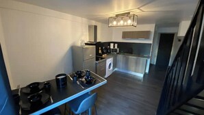 A compact kitchen with a gas stove, a washing machine, and a microwave. - Le Bill'ppart Easy Life (Bourgoin-Jallieu)