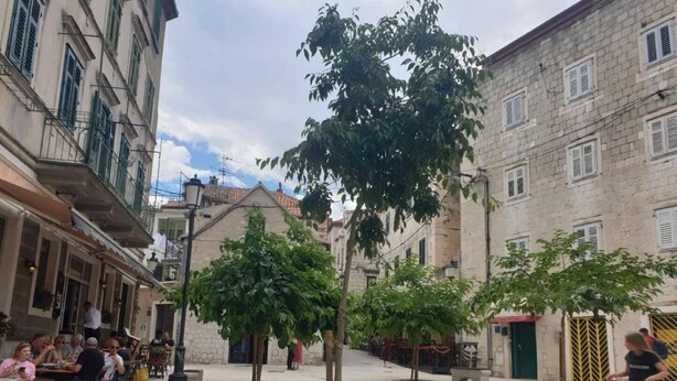 A courtyard with outdoor seating, trees, and buildings with balconies. - Iva - Modern Downtown - A2 Navada (Split)