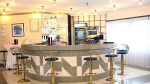 Un'area bar con un bancone, sgabelli e un frigorifero.