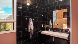 A modern bathroom with black tiles, a white sink, and a mirror. - Eklo Hotels Montpellier City center Saint-Roch train station (Montpellier)
