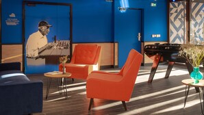 A modern lounge area with a blue wall, a chessboard, and a vintage radio. - Eklo Hotels Montpellier City center Saint-Roch train station (Montpellier)
