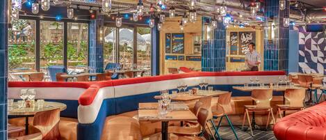 Un restaurante con una barra larga, mesas y cabinas.
