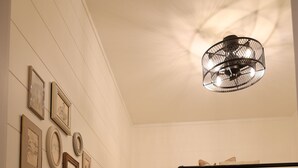 Una cama litera con estructura de madera y una lámpara en el techo.