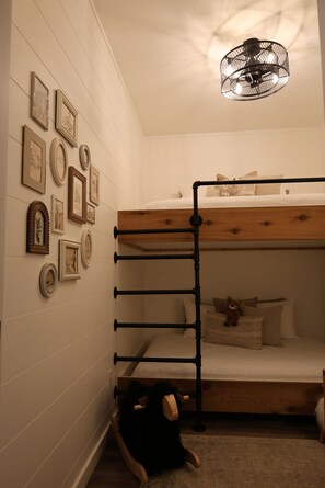 A bunk bed with a wooden frame and a ceiling light fixture.