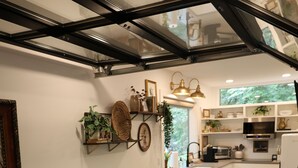 Un soggiorno moderno con un divano marrone, un tavolino in legno e un'area pranzo con una sedia verde.