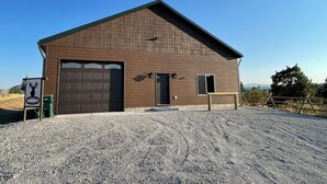 A wooden barn with a large garage door, a small entrance door, and a signboard. - SPORTSMAN'S PARADISE (Helena)