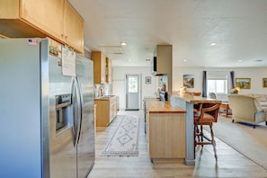 Una cocina amplia con gabinetes de madera, un refrigerador de acero inoxidable y una isla central.