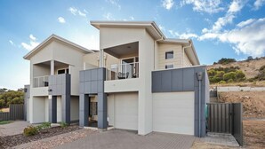 A modern two-story house with a balcony, a garage, and a gated entrance. - Sunny Dais Beachfront - stunning views of the Marina, Clifftops and Port Vincent (Port Vincent)