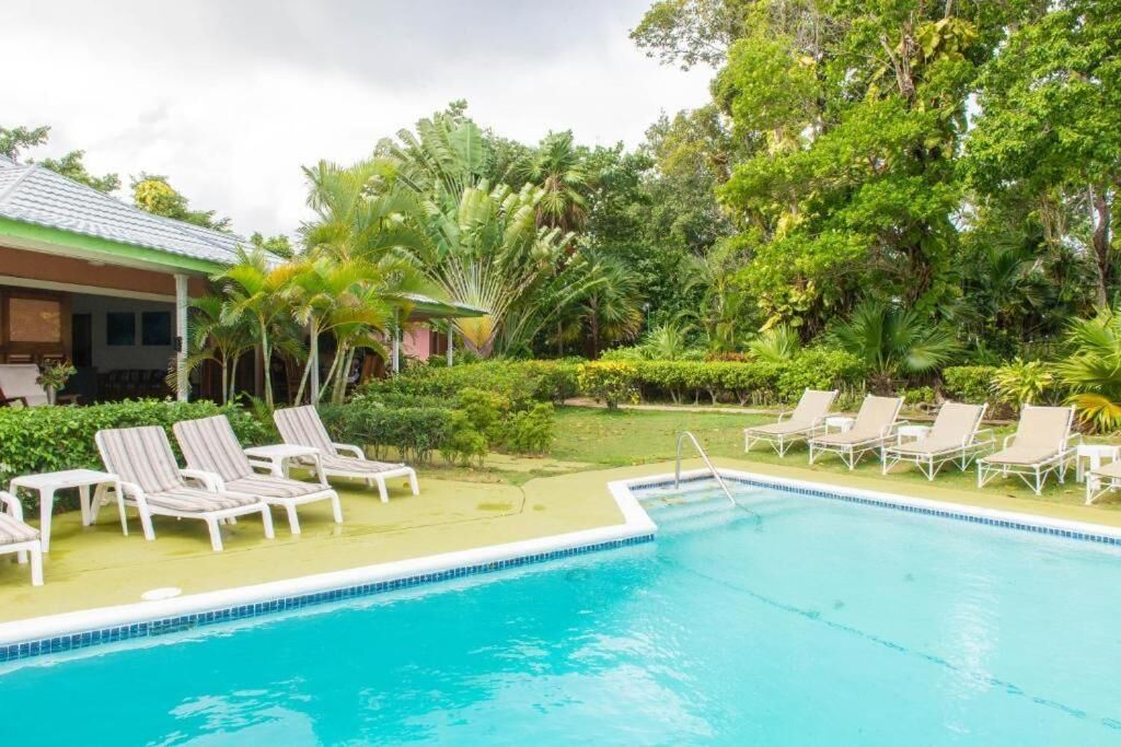 A swimming pool with lounge chairs and a building in the background.